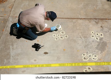a crime scene detective investigates and gathers evidence at a drive by shooting crime scene.