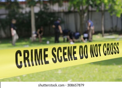 crime scene do not cross tape and blurred law enforcement and forensic background
