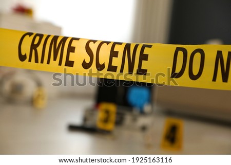 Crime scene with evidences and criminologist case, focus on yellow tape