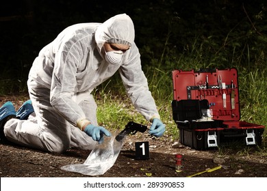 Crime scene investigation - collecting pistol and cartridges by technician