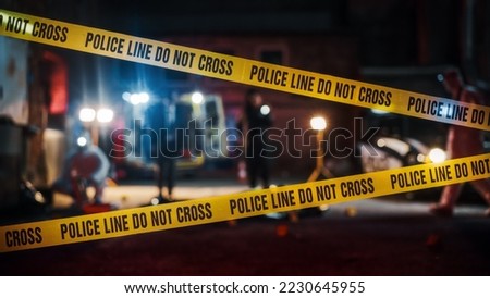Crime Scene at Night: Crime Scene Investigation Team Working on a Murder. Female Police Officer Briefing Detective on the Victim's Body. Forensics and Paramedics Working. Cinematic Shot