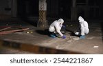 Crime scene, people and forensics at night with swab, evidence or DNA sample clue in abandoned warehouse. CSI team, hazmat suit or investigation in building for legal service, inspection or pathology