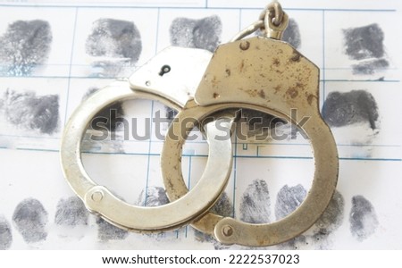 Crime and violence concept.Gun and Police Handcuffs on fingerprints crime page file
