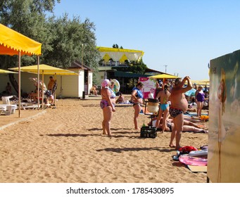   Crimea, Feodosia, July 26, 2012. City Beach, Fat Man And Woman In Bathing Suits Sunbathe On The Sand                             