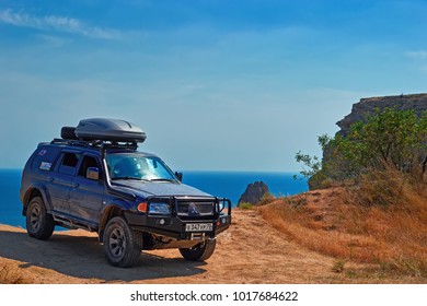CRIMEA, RUSSIA - AUGUST 10, 2017: Off-road vehicle on the edge of the cliff at Cape Fiolent (985 feet high) on the southern coast of the Crimean peninsula near the city of Sevastopol.