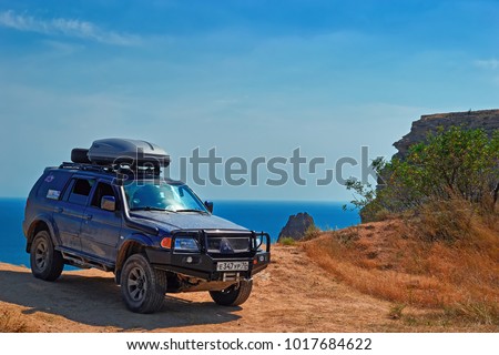 CRIMEA, RUSSIA - AUGUST 10, 2017: Off-road vehicle on the edge of the cliff at Cape Fiolent (985 feet high) on the southern coast of the Crimean peninsula near the city of Sevastopol.