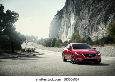 Crimea, Russia - September 20, 2015: Red car Mazda standing on the road near mountains at daytime