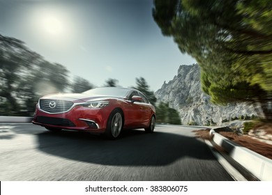 Crimea, Russia - September 20, 2015: Red car Mazda speed driving on asphalt road near mountain at daytime