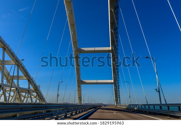 Crimean\
bridge, Taman, Russia - 11,09,2020: The navigable arch of the\
Crimean bridge. Arch of the highway and railway section of the\
Crimean bridge. Driving along the Crimean\
bridge.