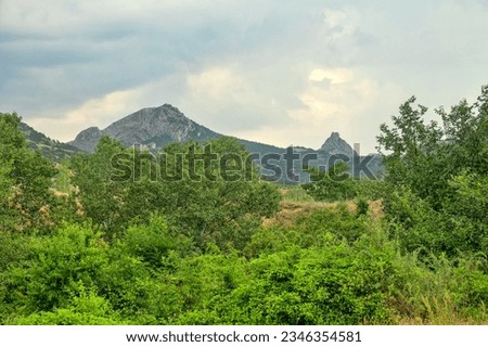Crimean mountains. Foot of main ridge. Glen, stream. Subtropics. Deciduous trees (poplars form urema), bush, meadow. Orogenic movements belong to type of old collapsing mountains. Rotted rocks, butte
