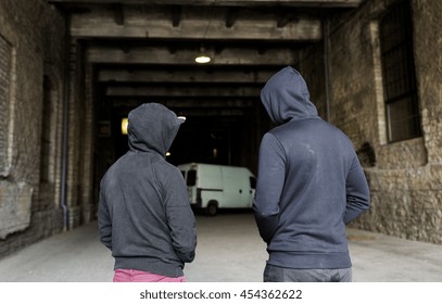criminal activity, addiction, people and social problem concept - close up of addict men or criminals in hoodies on street - Shutterstock ID 454362622