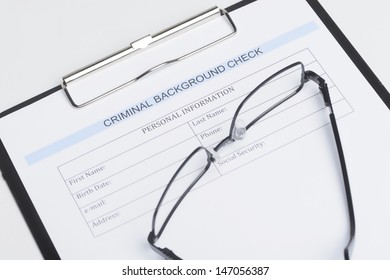 Criminal background check document. Close-up of criminal background check document with a eyeglasses lying on it