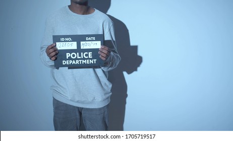 A Criminal Is Being Photographed. Mugshot Sign
