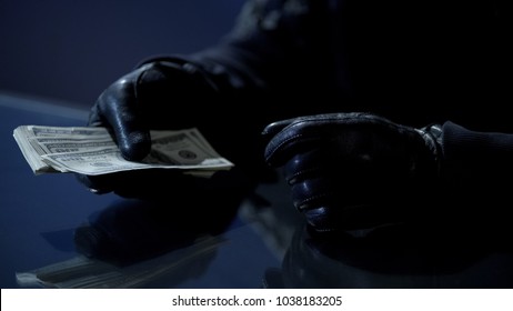 Criminal counting ransom money for kidnapping, blackmail, contract killing - Shutterstock ID 1038183205