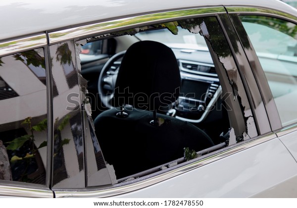 Criminal incident. Hacking the car. Broken\
window of a car. Broken car\'s window. Concept of vandalism, crime\
and theft of personal stuff from the\
car.