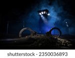 Criminal justice imprisonment concept. Handcuffs and Old prison watchtower protected by wire of prison fence at night. Creative art decoration. Selective focus