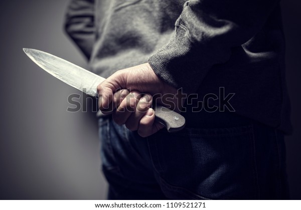 Criminal with\
knife weapon hidden behind his\
back