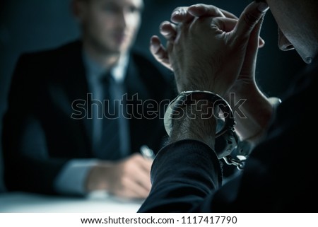 Criminal man with handcuffs in interrogation room feeling guilty after committed a crime ストックフォト © 