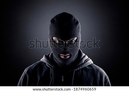 Criminal wearing black balaclava and hoodie in the dark Stock photo © 
