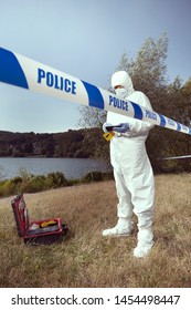 Criminologist Technician Behind Police Barrier Tape On Outdoor Location