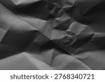 Crinkled paper background in grayscale, featuring a textured, abstract pattern with shadows and folds.