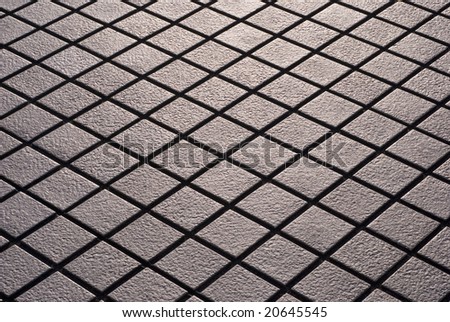 Cris-crossed design of diamond shaped street tiling.