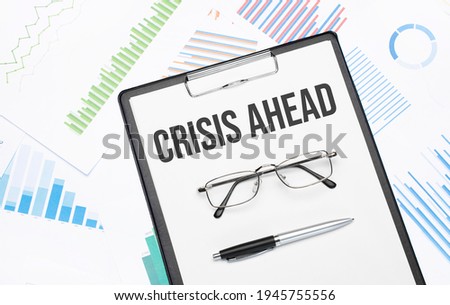 CRISIS AHEAD sign. Conceptual background with chart ,papers, pen and glasses