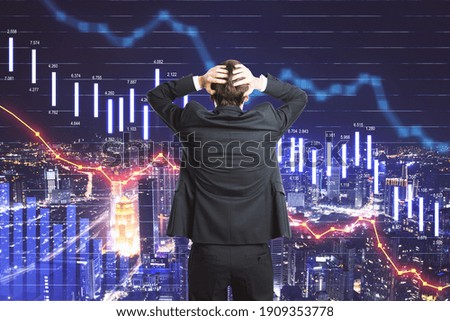 Crisis concept with businessman in a panic and digital business chart screen with graphs going down. Double exposure