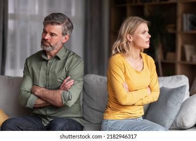 Crisis In Relations. Middle Aged Husband And Wife Offending To Each Other After Argue, Grumpy Spouses Sitting On Couch With Folded Arms, Married Couple Angry After Domestic Quarrel, Free Space