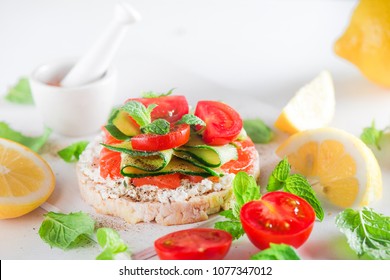 Crisp Bread Healthy Snack With Salmon, Cottage Cheese, Cucumber Stripes, Fresh Cherry Tomatoes, Mint, Lemon Juice, Pepper. Easy Breakfast Close-up On A White Background With Copy Space.