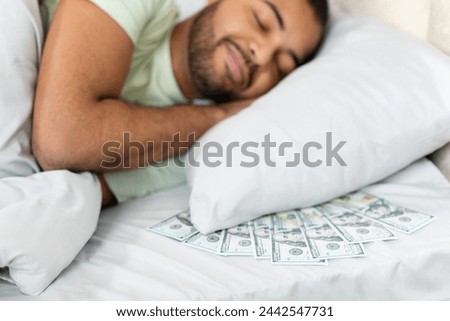 Crisp hundred-dollar bills are spread on a bed, symbolizing financial concepts or unexpected windfall. Bad guy sleeping with his money