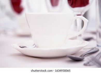 Crisp White Tea Cup And Saucer On A Laid Table With A Clean White Table Cloth 