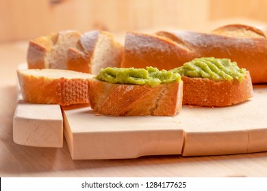 Crispy Appetizing Sandwiches From Fresh Baguette With A Cream Useful Avacado Cream On A Chopped Board. With Scattered Crumbs