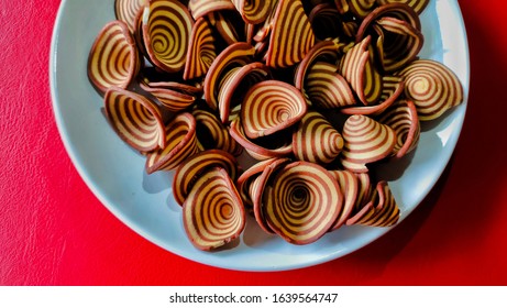 Crispy Biscuits Named Elephant Ears/ Cow Ears Or Pig Ears, Are Isolated On A White Plate With A Red Background