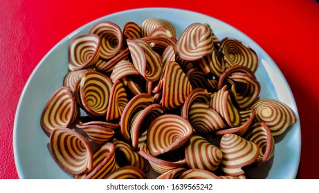 Crispy Biscuits Named Elephant Ears/ Cow Ears Or Pig Ears, Are Isolated On A White Plate With A Red Background