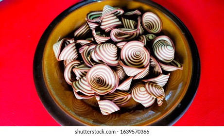 Crispy Biscuits Named Elephant Ears/ Cow Ears Or Pig Ears, Are Isolated On A Brown Plate With A Red Background