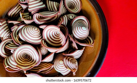 Crispy Biscuits Named Elephant Ears/ Cow Ears Or Pig Ears, Are Isolated On A Brown Plate With A Red Background