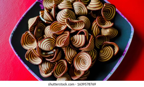 Crispy Biscuits Named Elephant Ears/ Cow Ears Or Pig Ears, Are Isolated On A Purple Plate With A Red Background