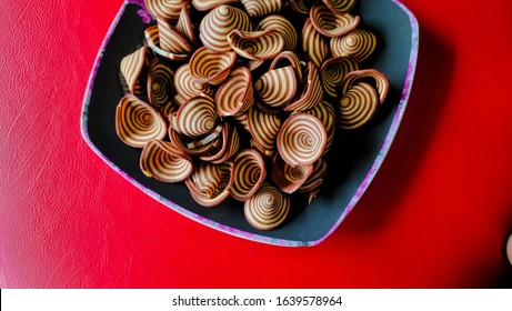 Crispy Biscuits Named Elephant Ears/ Cow Ears Or Pig Ears, Are Isolated On A Purple Plate With A Red Background