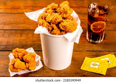 Crispy Boneless Chicken Wings Bites 12 Piece With Drink And Ketchup Served In A Basket Isolated On Wooden Board On Grey Background Side View Of Fastfood