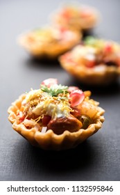 Crispy Canape or canapé is a starter recipe from India - Round or square shaped Puri Filled with Yogurt and potato , chat, sev, tamarind sauce etc. selective focus