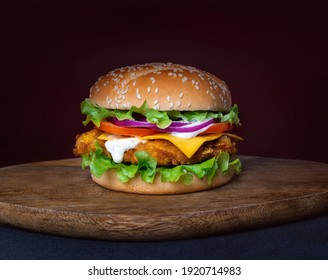 Crispy-Huhn-Käse-Burger auf Holzteller 