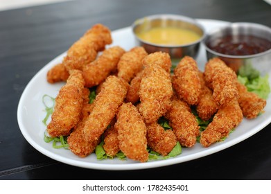 Crispy Chicken Fingers In A Plate With Sauce