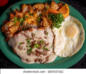 A Crispy Chicken Fried Steak With Cheesy Potatoes, Eggs And Gravy.