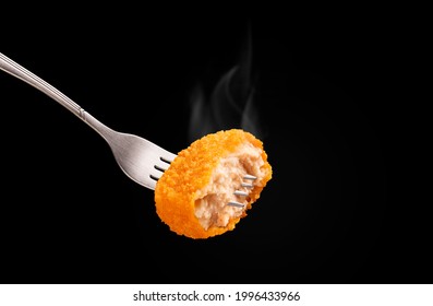 Crispy Chicken Nugget On Fork Against With Smoke On A Black Background.