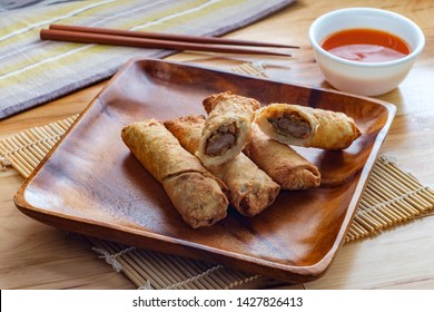 Crispy Chinese Fried Egg Rolls With Duck Sauce On Wooden Table