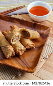 Crispy Chinese Fried Egg Rolls With Duck Sauce On Wooden Table