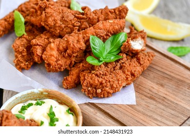 
 Crispy  deep Fried   Chicken strips and wedges potato. Breaded  with cornflakes chicken  breast fillets  with chilly peppers and fresh   basil on wooden rustic background