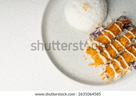 Crispy deep-fried shrimp lined up over shredded cabbage and carrots, drizzled with Japanese mayonnaise and served with a round mound of rice.