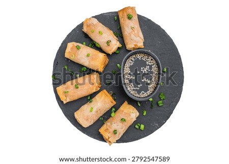 Crispy Egg Rolls served on round slate plate with soy sauce and sesame seeds top view on white background.